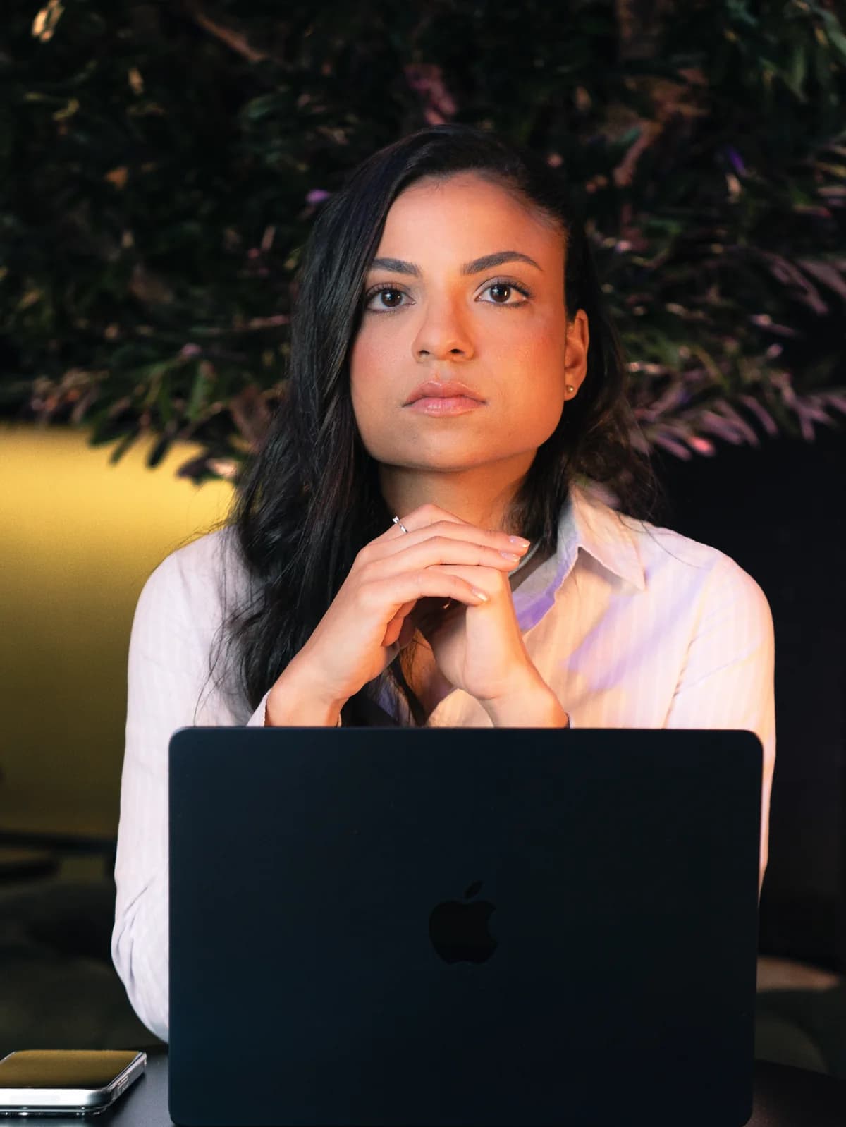 Juliana Queiroz sentada à mesa com seu notebook